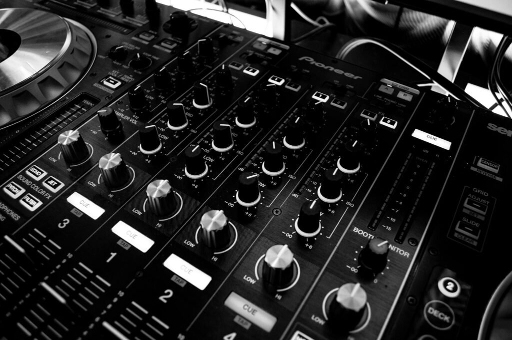 pexels photo 63703 63703 Black and white close-up of a DJ's audio mixing console with knobs and controls.